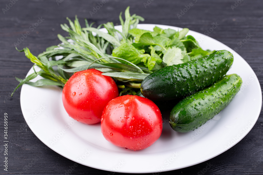 Plate with vegetables fresh, tomatoes and cucumbers with greens Plate with vegetables fresh, tomatoes and cucumbers with greens