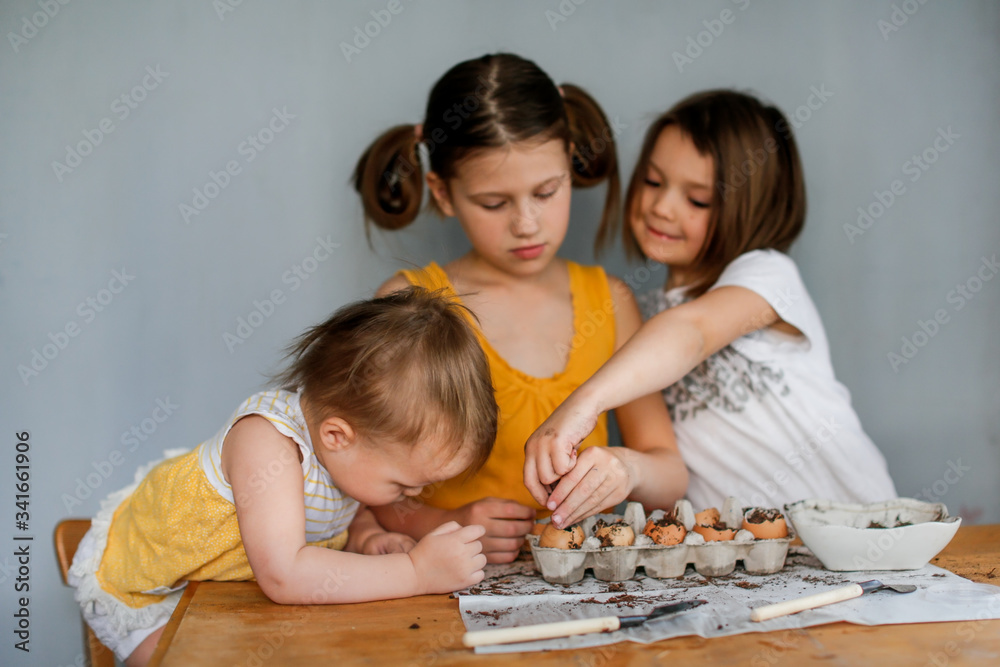 Children sow seeds in pots of eggshells, garden