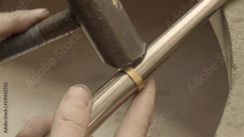 goldsmith sizes a golden ring using hammer