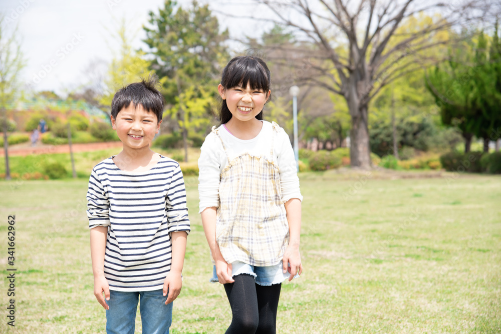 緑の多い公園で笑顔の姉弟 緑の多い公園で笑顔の姉弟