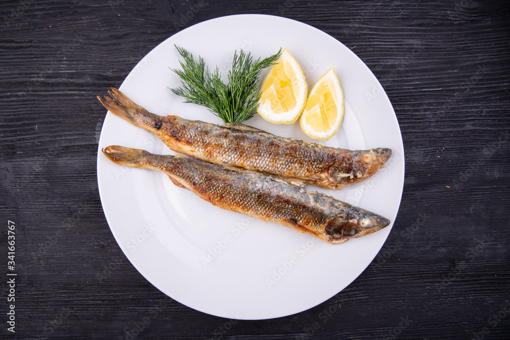 Mackerel fried on grill, served with lemon and dill Mackerel fried on grill, served with lemon and dill