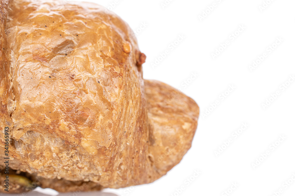 One whole baked wholegrain croissant closeup isolated on white One whole baked wholegrain croissant closeup isolated on white