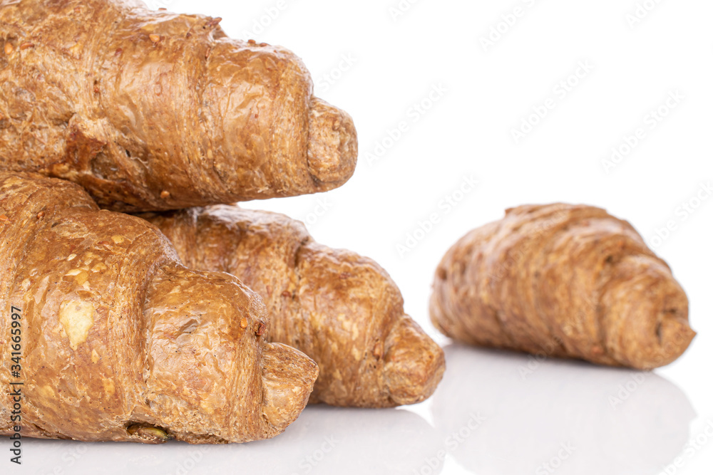 Group of four whole baked wholegrain croissant closeup isolated on white
