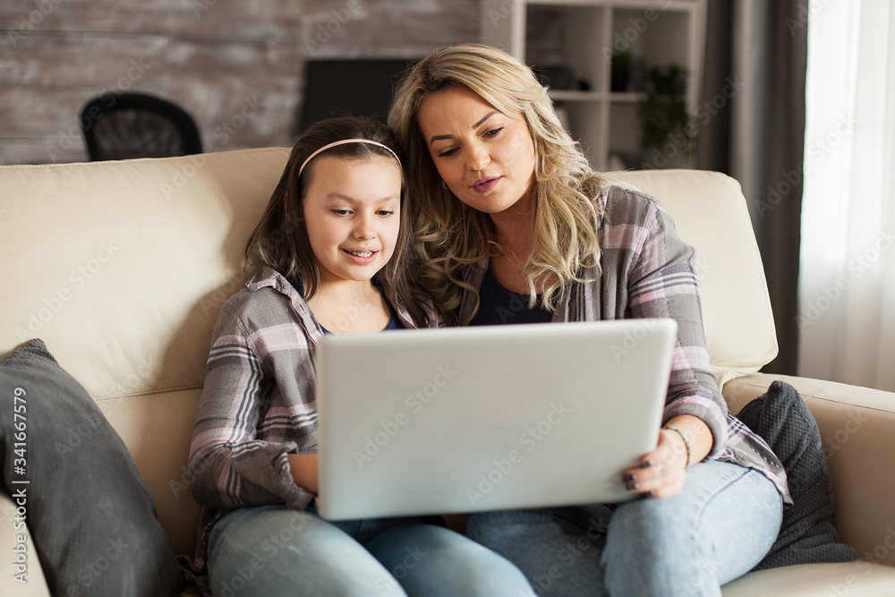 Mother and daughter sitting on the couch in living room