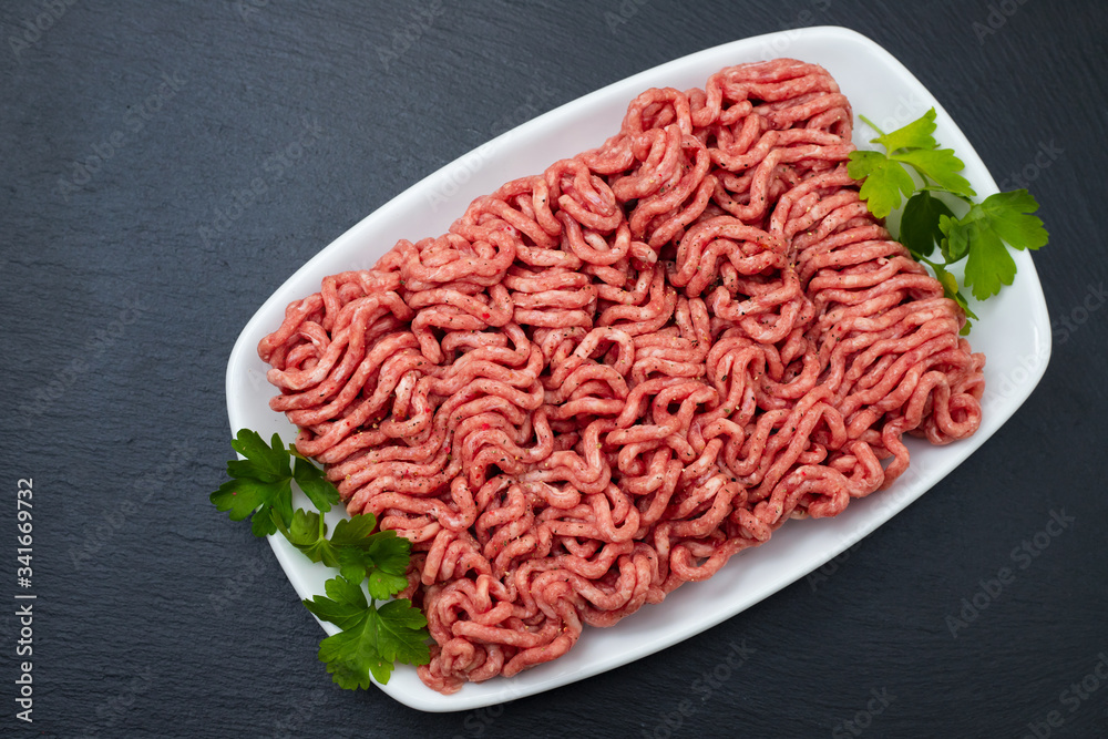 ground meat on white dish on black ceramic background ground meat on white dish on black ceramic background