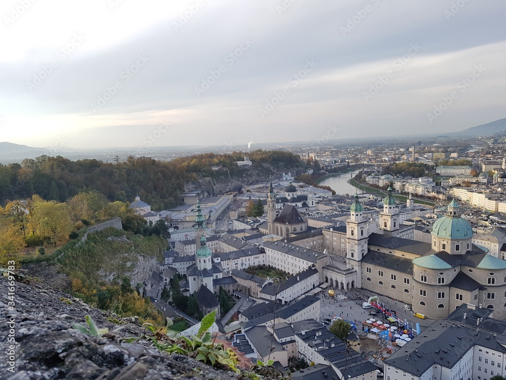 View over old town city of Salzburg warm light sunset sundown autumn colourfull view tree from castle fortress stone