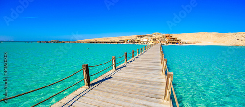 Wooden Pier at Orange Bay Beach with crystal clear azure water and white beach - paradise coastline of Giftun island, Mahmya, Hurghada, Red Sea, Egypt. photo