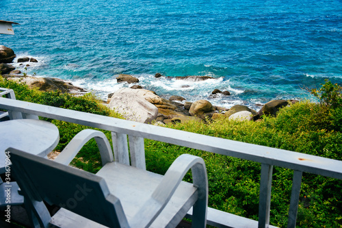 Nice sea view from a balcony of a hotel. Chair with table set on balcony hotel room with ocean view background.