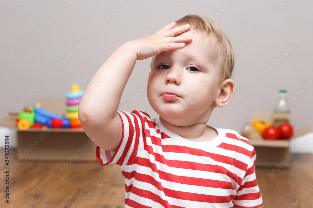 child boy holds his hand on his face on the background of donation boxes. donation box child boy holds his hand on his face on the background of donation boxes. donation box