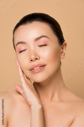 beautiful tender asian girl with clean face and closed eyes isolated on beige