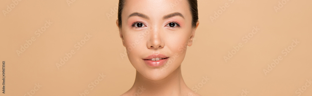 panoramic shot of attractive asian girl with nude makeup isolated on beige
