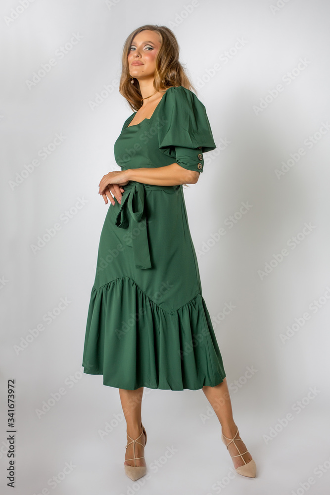 Blonde model posing in full length green dress Blonde model posing in full length green dress