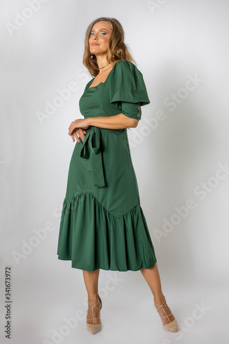 Blonde model posing in full length green dress