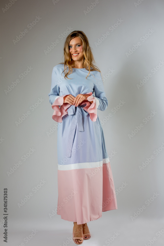 Beautiful blonde woman posing in blue and pink dress Beautiful blonde woman posing in blue and pink dress