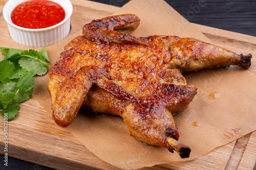 Chicken tobacco fried on coal with garlic, served with greens and ketchup photo