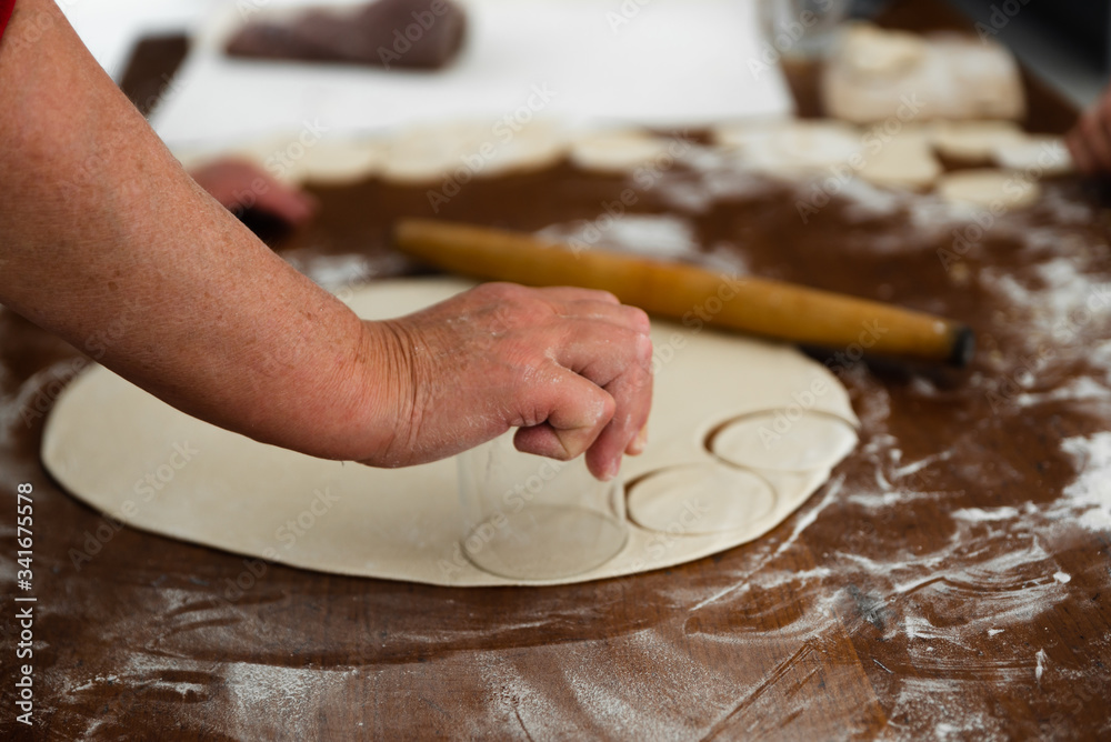 cooking dumplings,cutting dough into circles,chopped dough on the table cooking dumplings,cutting dough into circles,chopped dough on the table