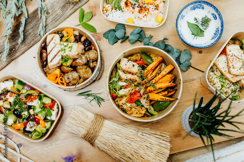Fototapeta Naklejka Na Ścianę i Meble -  Various healthy and vitamin-rich dishes and food in an ecobox delivered by a delivery service, ordered online, decorated with bundles of straw, mussels and cacti, in a Mediterranean style