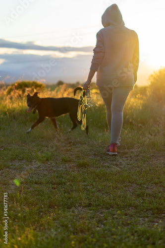 woman with sportswear on her back has two dog leashes in her hand © Pablo G. Mediavilla