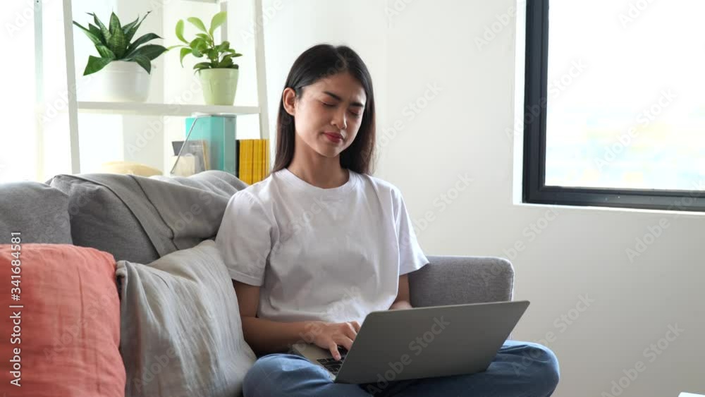 Asian women are working online using a laptop computer, She is tired and has a pain in the neck. Asian women are working online using a laptop computer, She is tired and has a pain in the neck.