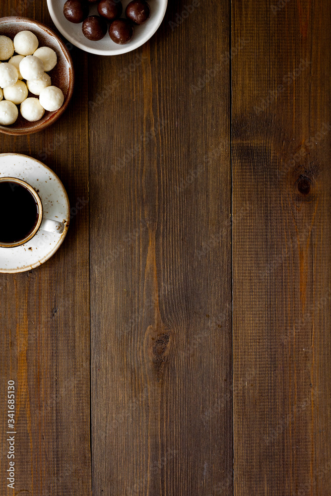 Chocolate pieces and coffee on wooden desk top view frame - set of sweets - copy space Chocolate pieces and coffee on wooden desk top view frame - set of sweets - copy space