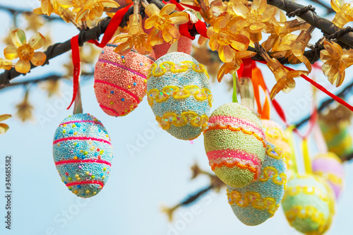 multi-colored easter eggs hanging on a branch