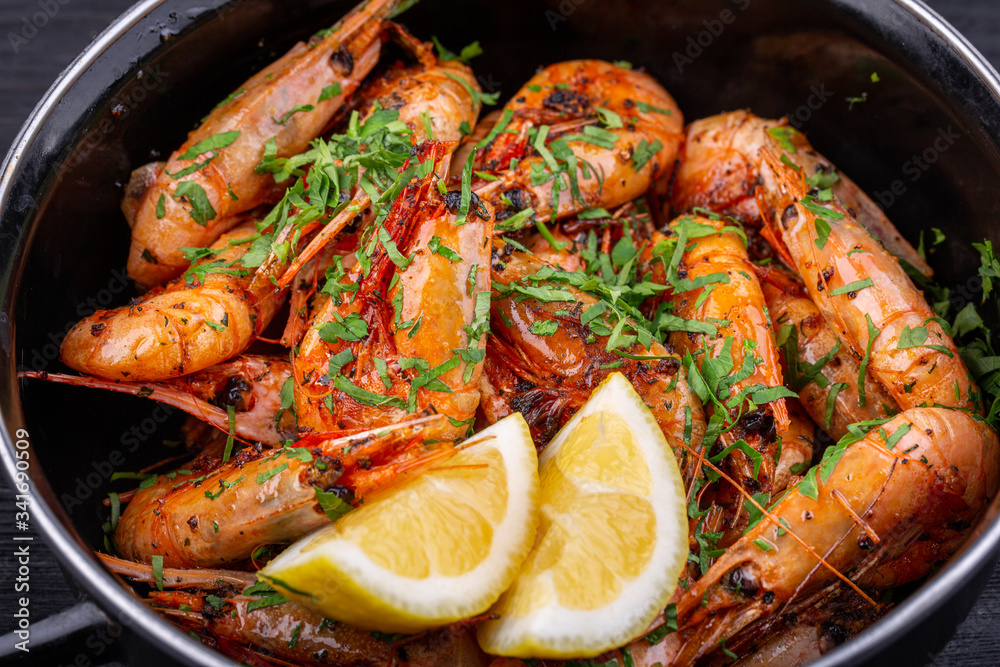 Fried shrimp on oil, served with greens and lemon Fried shrimp on oil, served with greens and lemon