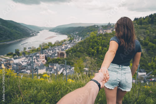 Eine Frau führt einen Mann an der Hand mit Blick auf die hügelige Landschaft des Rheintals