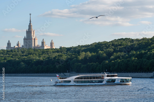 Touristic boat on Moscow river against Moscow State University. Moscow, Russia.