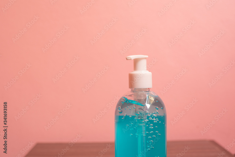 Close up blue alcohol gel on pink background.