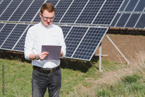 Engineer. Man near solar panel. Worker with a folder. © Serhii