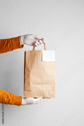 Safe delivery of food in a craft bag and pizza delivery man at home on a white background photo