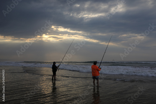 Two fishermen wait for a bite