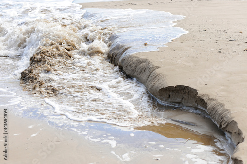 wave erosion on beach sand photo