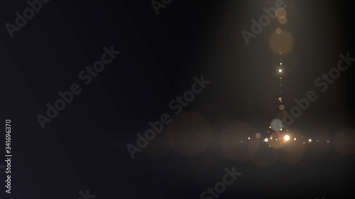 Golden little sparkles fall from above with blur effect in dark space, gold bokeh sand