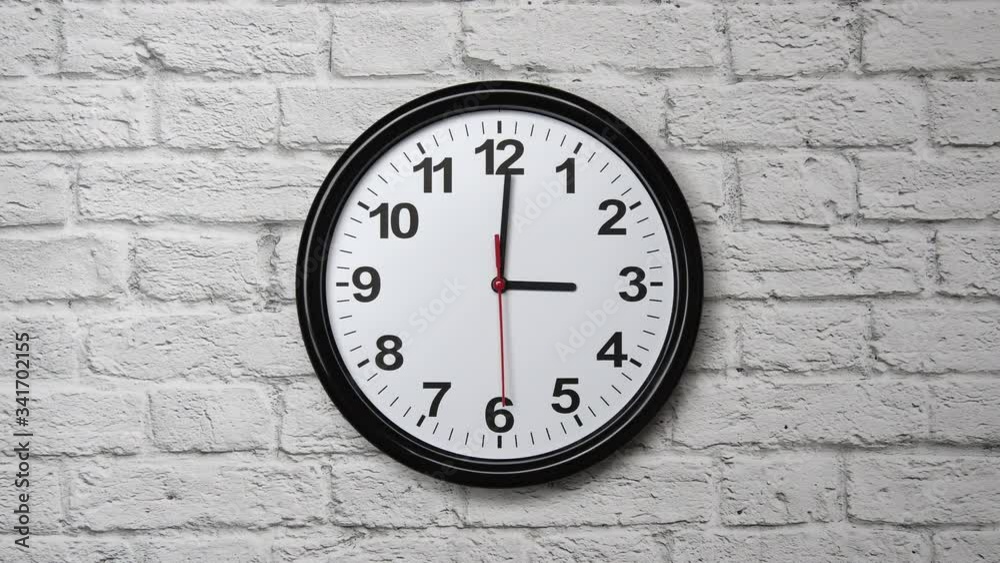 The Time On The Clock Three. Clock With The Black Arrows And Red Second Arrow With The Arabic Numerals On An White Brick Wall Background. The Time On The Clock Three. Clock With The Black Arrows And Red Second Arrow With The Arabic Numerals On An White Brick Wall Background.