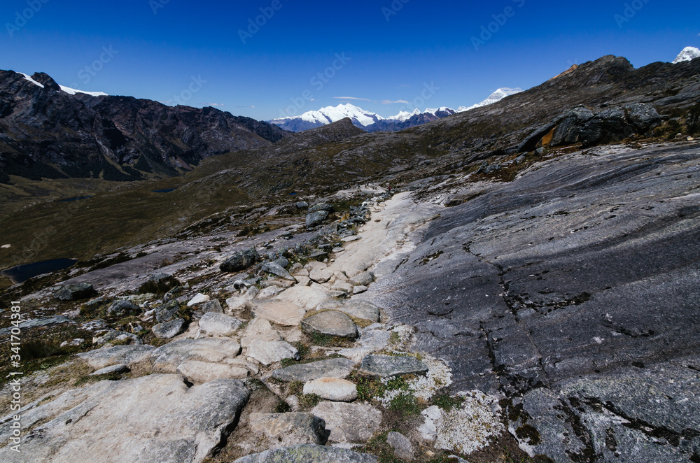 rocky path near punta union in the trekking of the quebrada santa cruz in peru with snowy mountain pucaraju in the background rocky path near punta union in the trekking of the quebrada santa cruz in peru with snowy mountain pucaraju in the background
