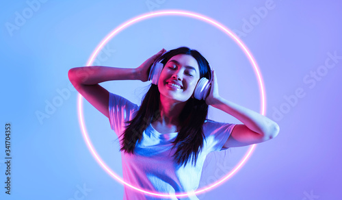 Asian woman in headphones with neon circle
