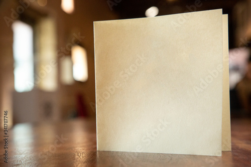 biglietto in bianco su un tavolo in legno isolato su sfocato su  interno di un locale photo