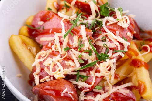 Salad with sausage, grated cheese, potatoes and ketchup with greens
