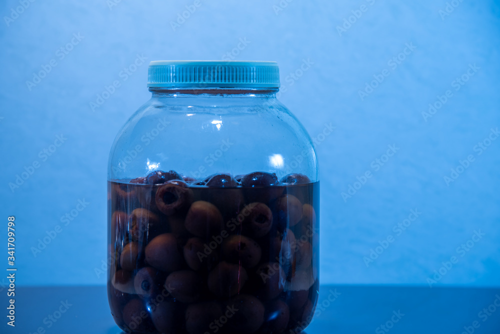 Glass container with brandy liquor soaked in butiá fruits (Butia capitata) Glass container with brandy liquor soaked in butiá fruits (Butia capitata)
