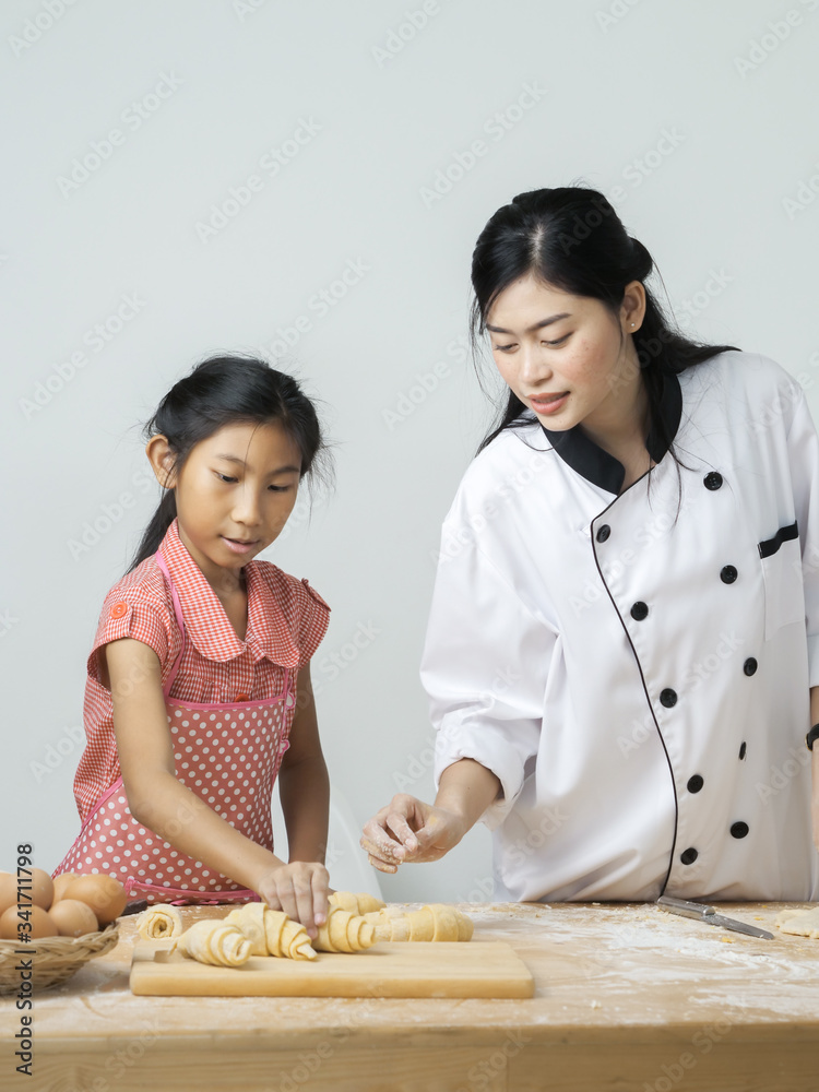 Asian girl learning with chef, how to processing croissant, lifestyle concept. Asian girl learning with chef, how to processing croissant, lifestyle concept.