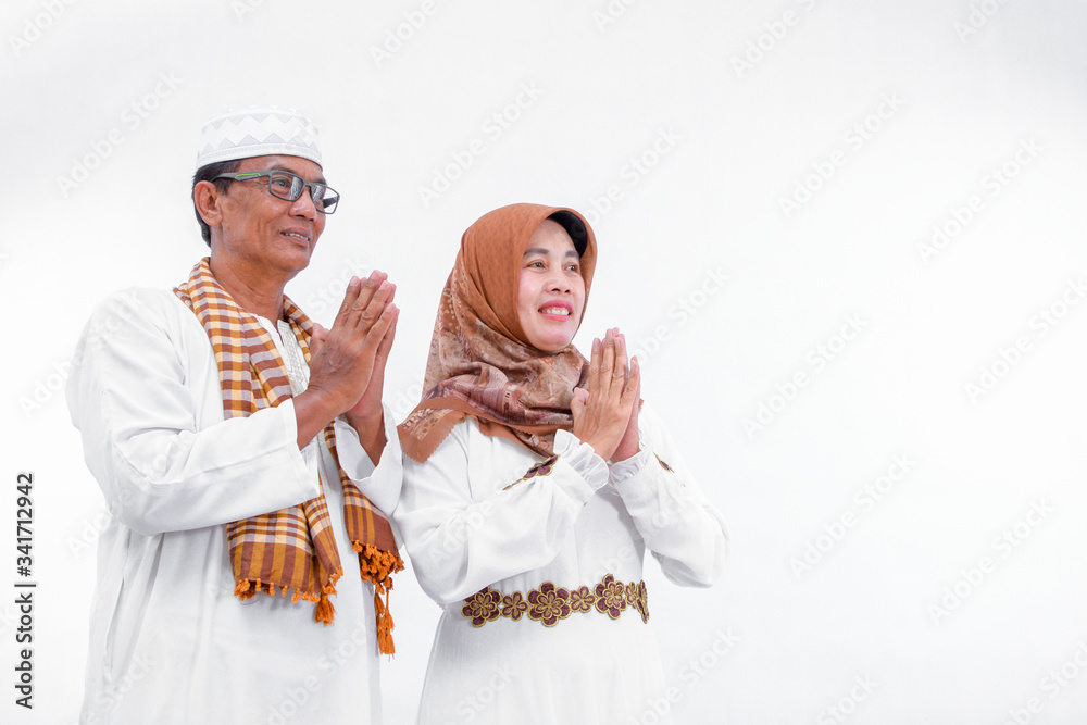 Portrait of a muslim couple who greeting and smiling on isolated white background Portrait of a muslim couple who greeting and smiling on isolated white background