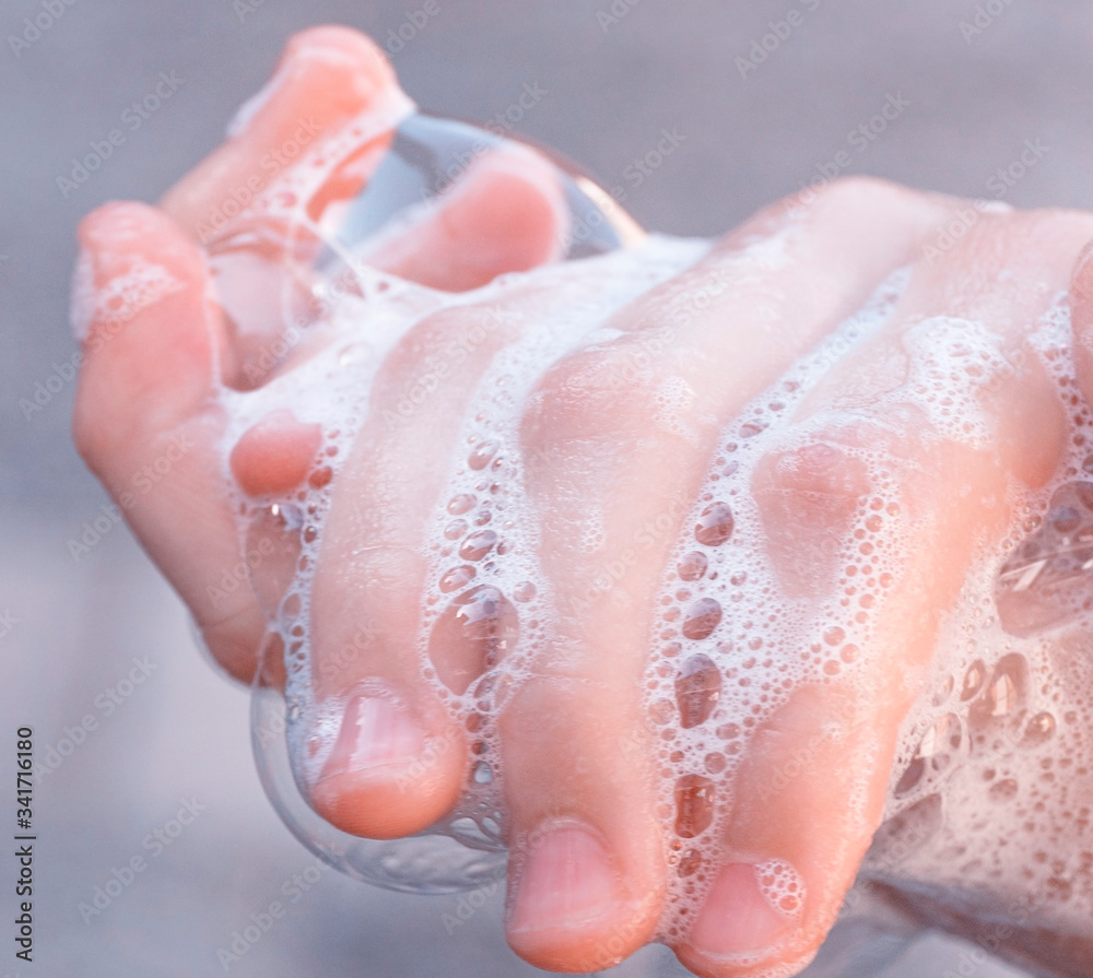 Fototapeta premium Soap foam on child hands. Covid - 19 Coronavirus prevention. A child wash our hands with antibacterial soap. Coronavirus pandemic protection by frequent hand washing. Selective focus