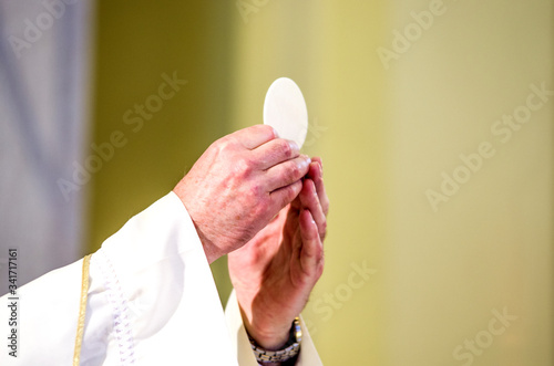 host that in the hands of the priest, as in the hands of Pope Francis, becomes the body of Christ photo