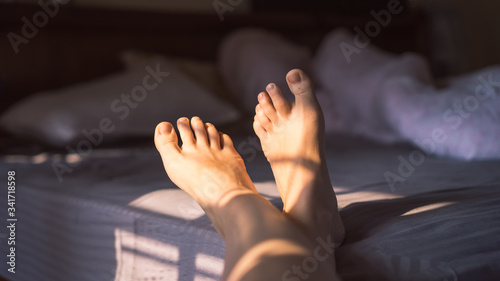 Close up photo of female feet on the bed in the morning, awakening, skip therapy, cropped image, Woman Body Legs Step Foot Sleep Relax Concept © Lesia Povkh