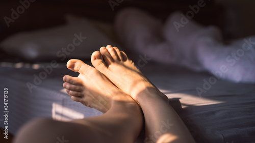 Close up photo of female feet on the bed in the morning, awakening, skip therapy, cropped image, Woman Body Legs Step Foot Sleep Relax Concept