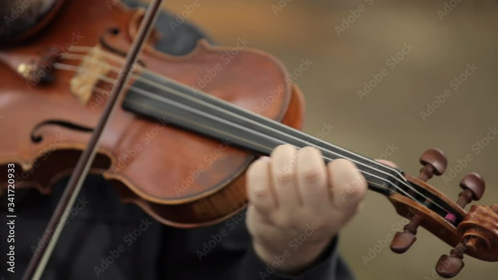Close up to the hands of an artist playing a beautiful violin in an elegant and professional way Close up to the hands of an artist playing a beautiful violin in an elegant and professional way