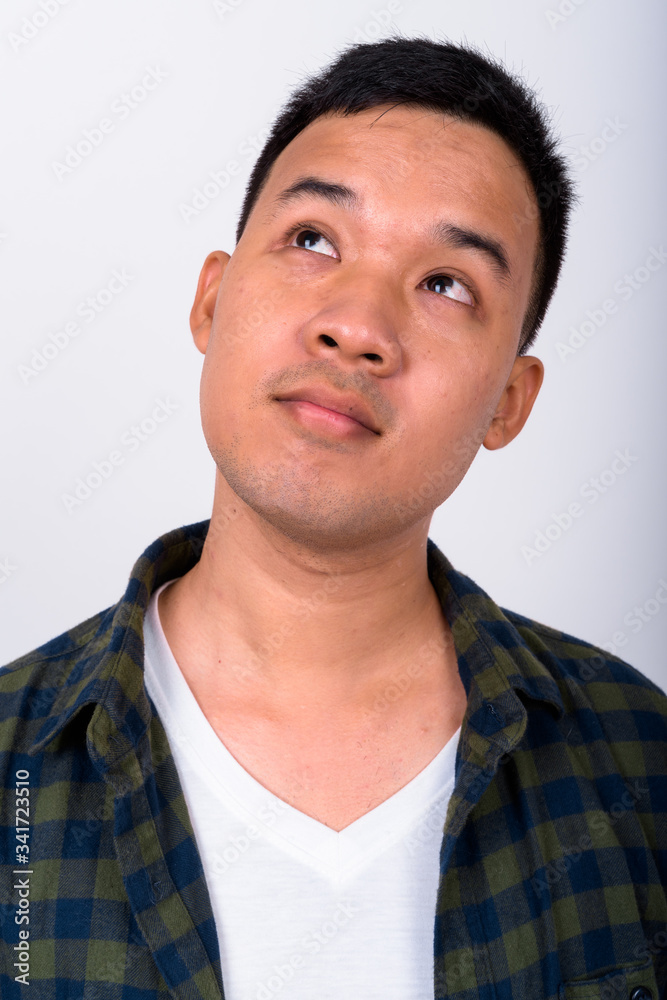Face of young Asian hipster man thinking Face of young Asian hipster man thinking