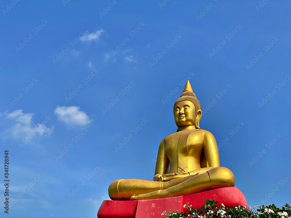 The big golden buddha with red base and the blue sky with cloud The big golden buddha with red base and the blue sky with cloud