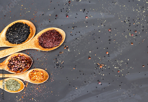 spices on a wooden spoon with black background